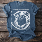 Blue t-shirt with "do not perceive me" text and a cat in a basket graphic.