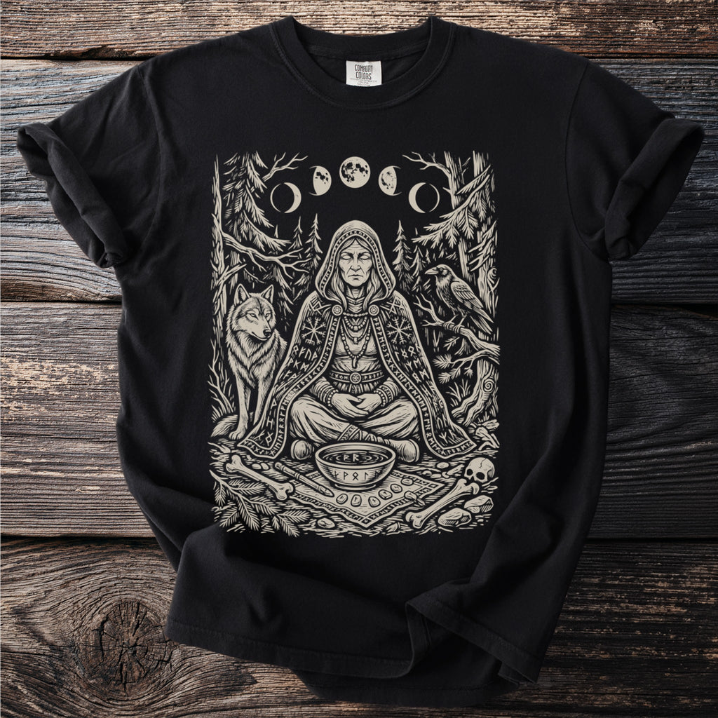 Black t-shirt with a black and white print of a meditating woman, wolf, raven, moons, runes, and bones.