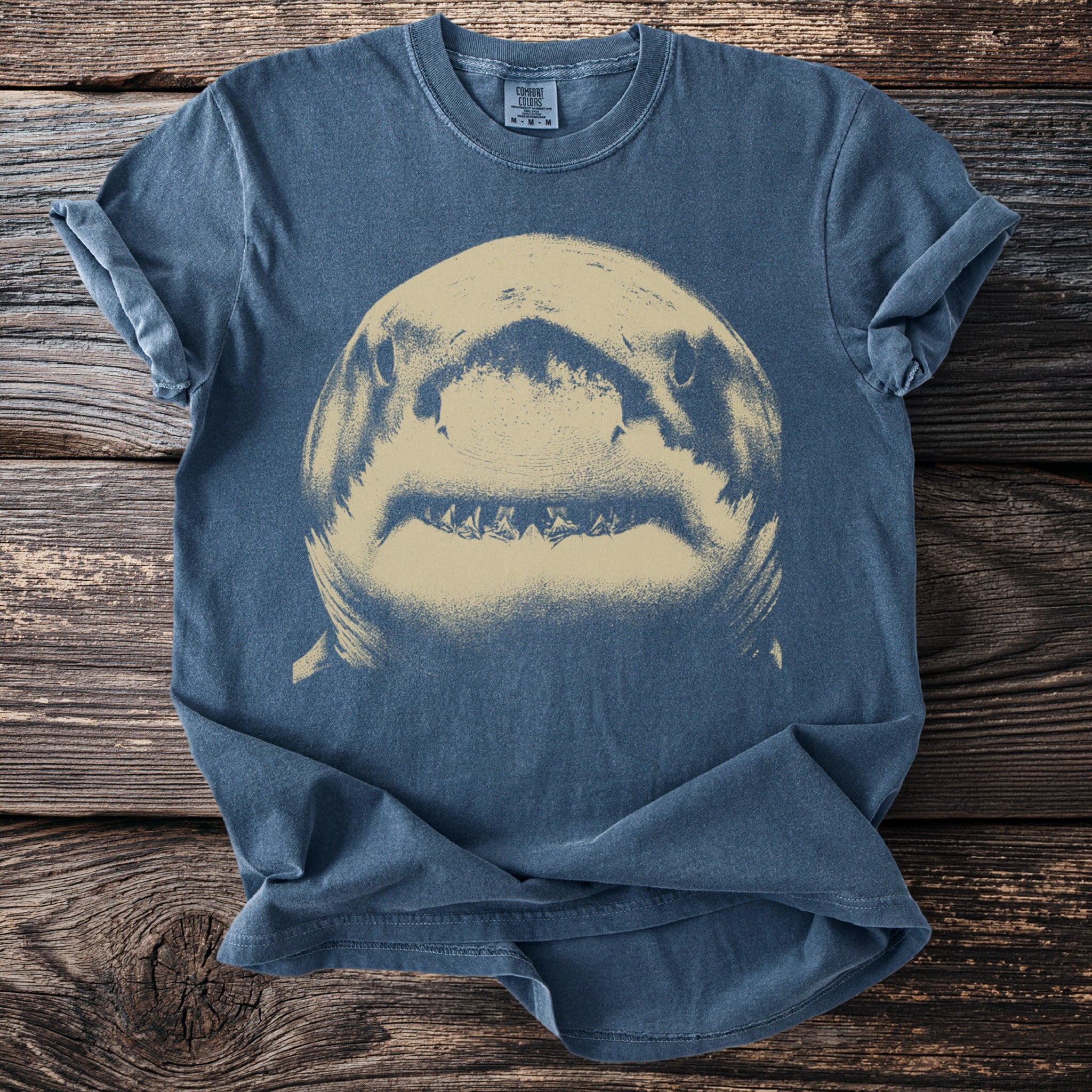 Blue Comfort Colors t-shirt with a close-up graphic of a shark's head and teeth.