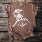 Brown t-shirt with white graphic of a creature and hands forming a heart with a lighthouse.
