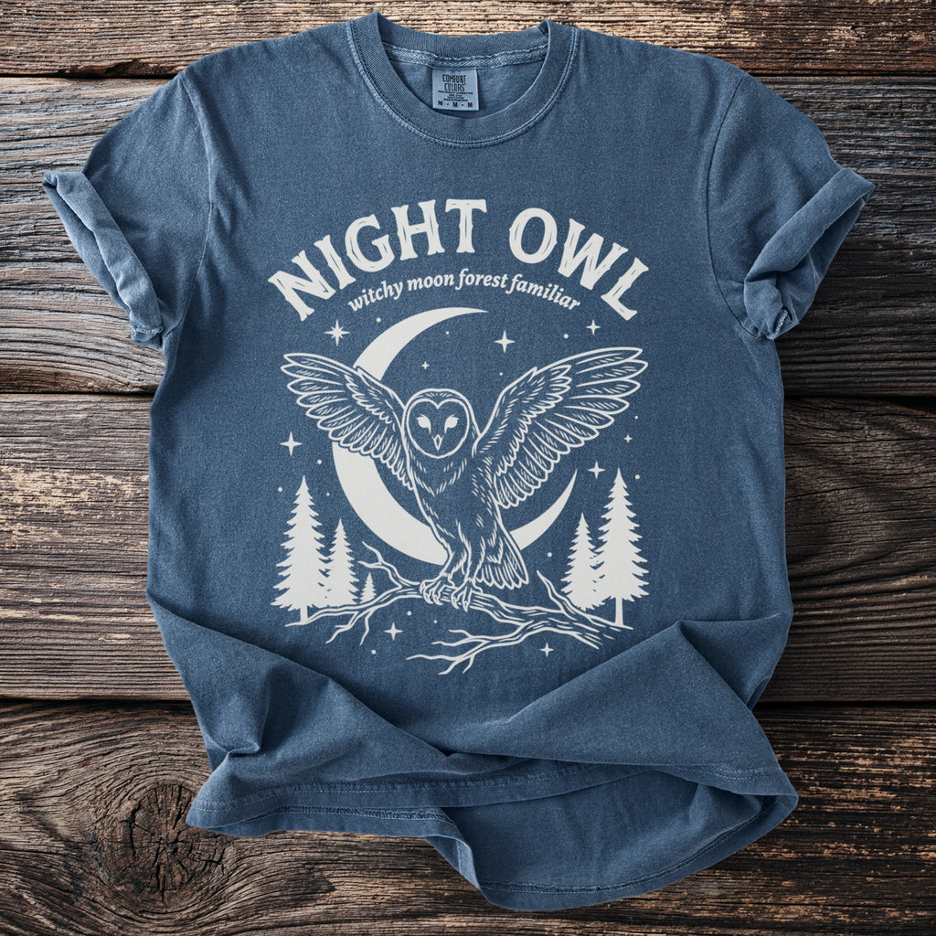 Blue t-shirt with a white graphic of a night owl, moon, and trees.