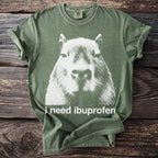 Green t-shirt with distressed white capybara graphic and text "i need ibuprofen".