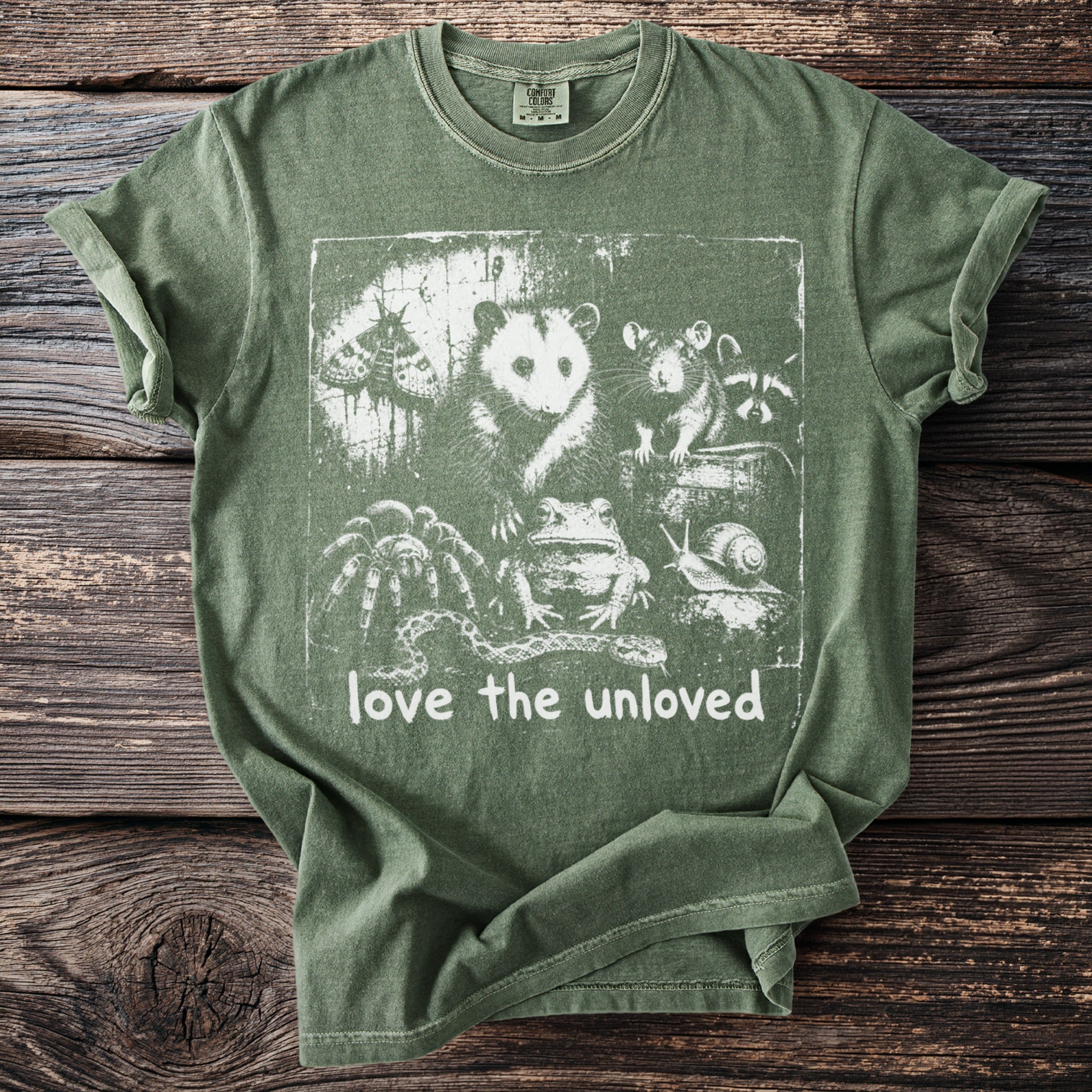 Green t-shirt with distressed graphic of opossum, moth, rat, raccoon, frog, spider, snake, and snail.