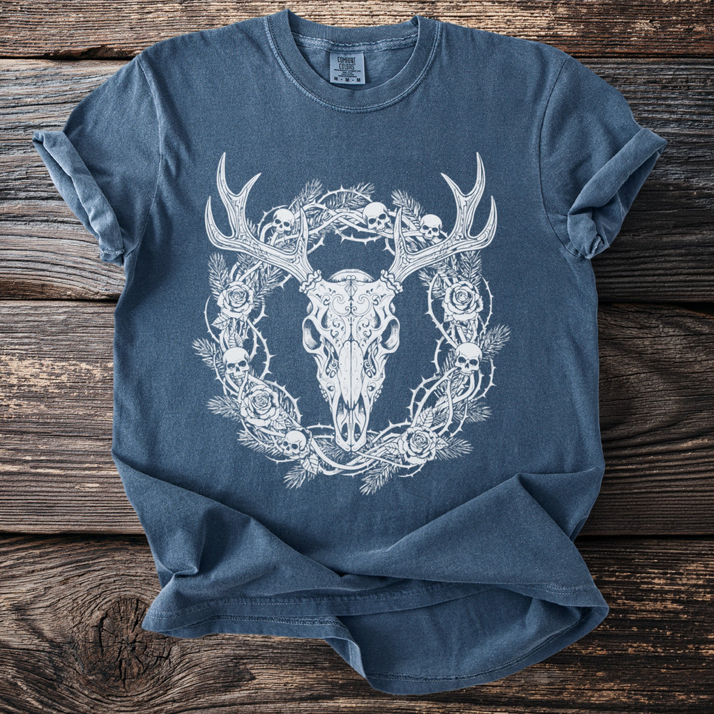 Blue t-shirt with a white illustration of a deer skull, thorny branches, skulls, and roses.