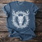 Blue t-shirt with a white illustration of a deer skull, thorny branches, skulls, and roses.