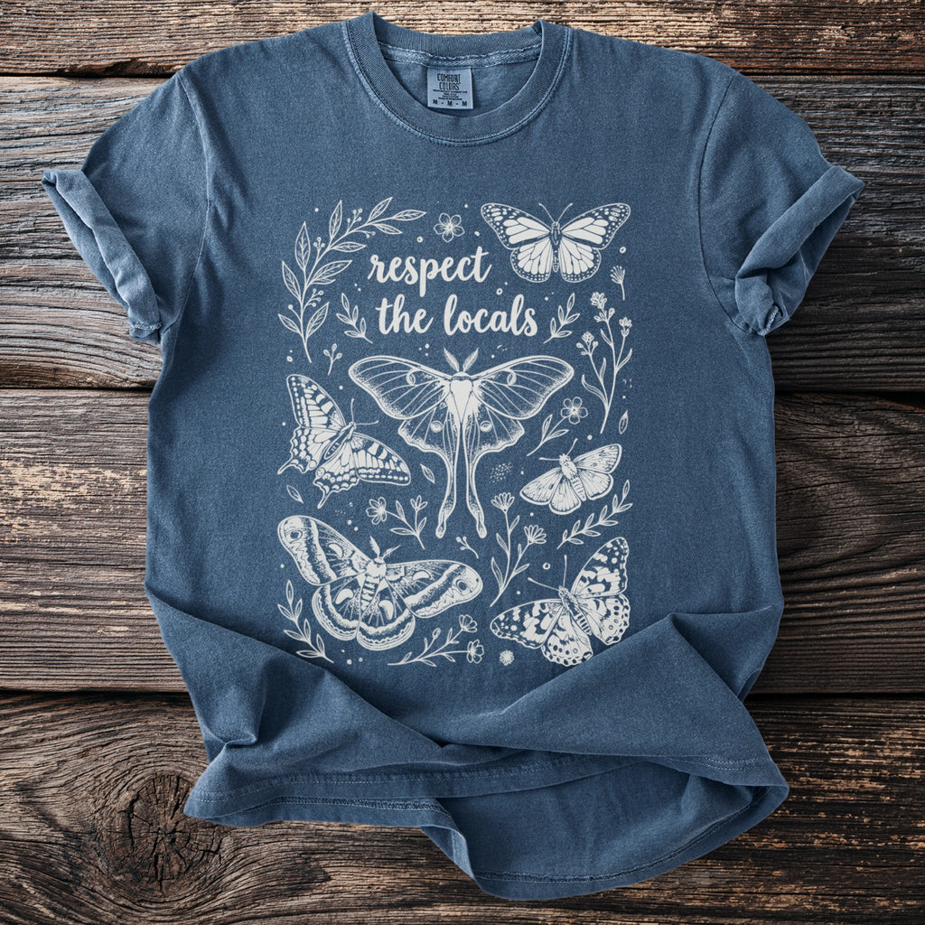 Blue t-shirt with white line art design of butterflies and the text "respect the locals".