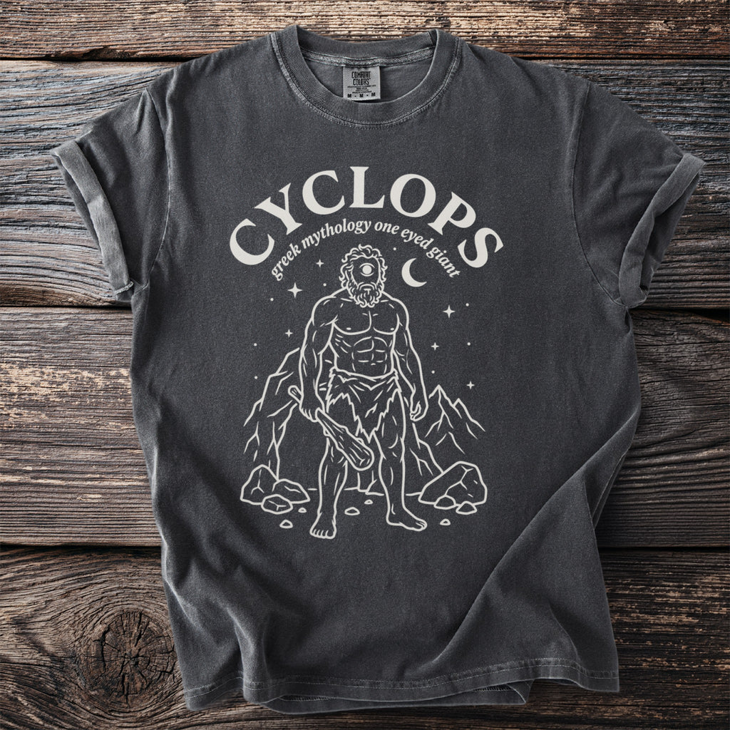 Dark t-shirt with white graphic of a cyclops and text "cyclops greek mythology one eyed giant".