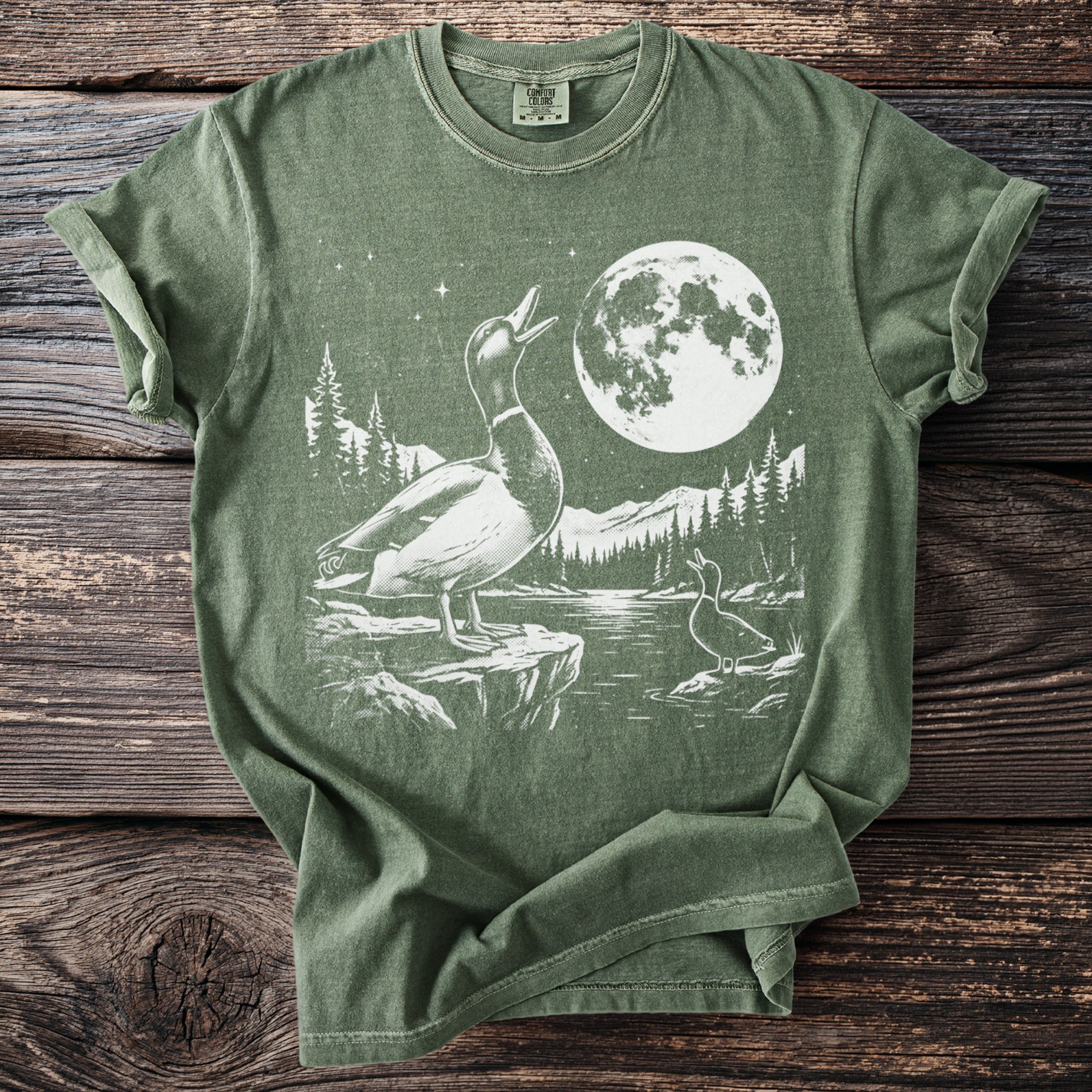 Two ducks under a full moon with a mountainous forest landscape graphic.