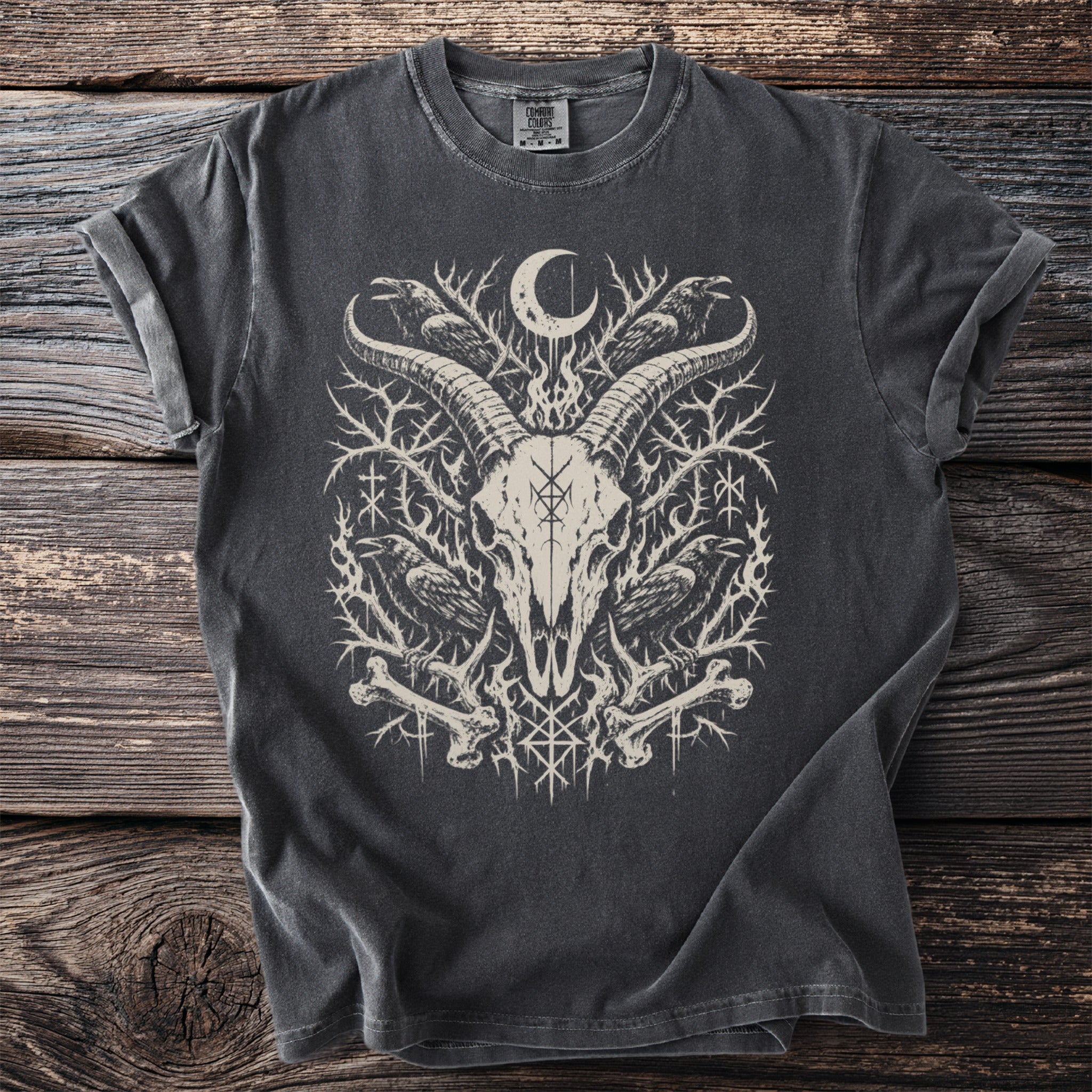 Dark grey t-shirt featuring a white graphic of a goat skull with ravens, bones, and runes.