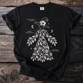 Black t-shirt with a white graphic of a witch adorned with plants and botanical names.