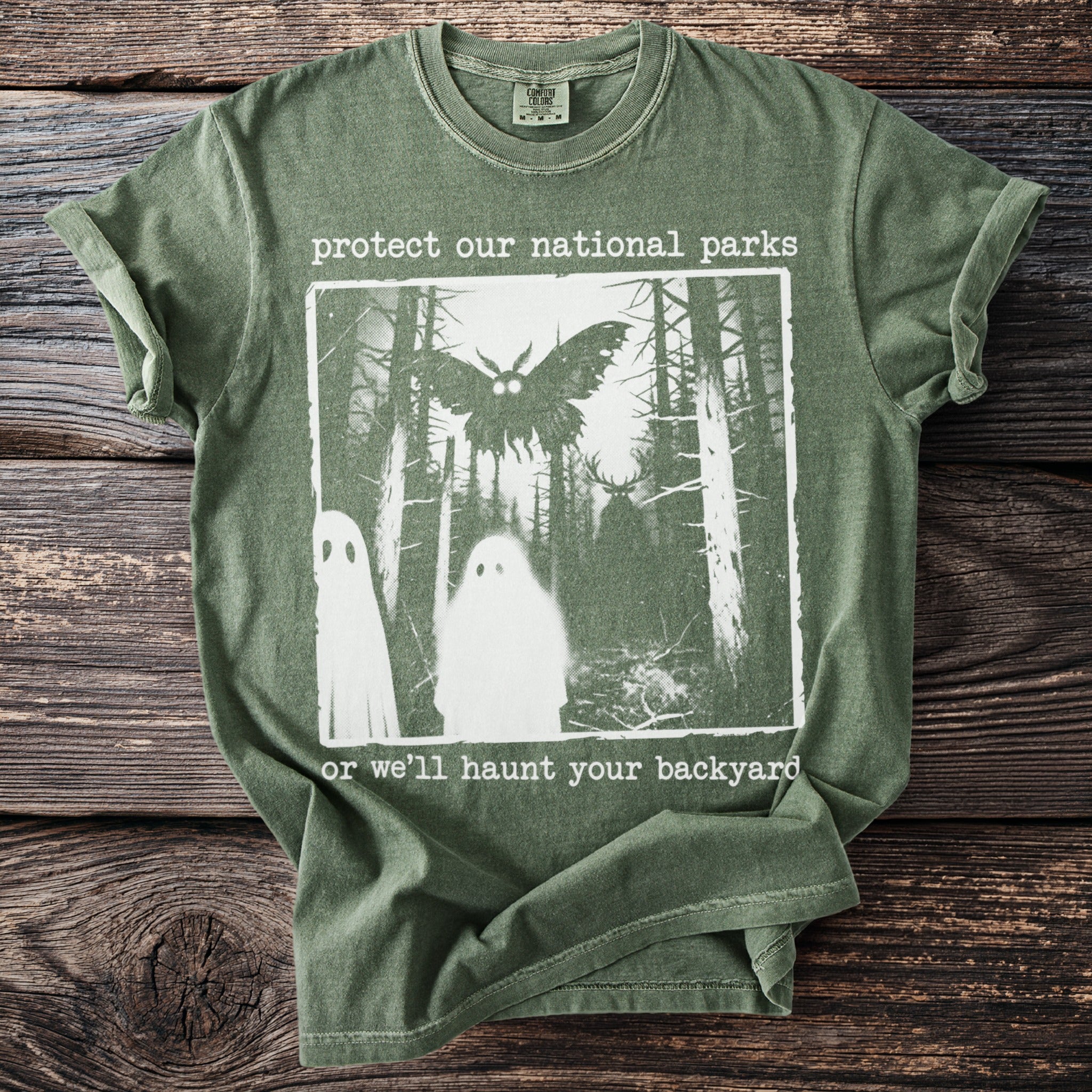Green t-shirt with "protect our national parks" and spooky forest graphic.