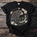 Black t-shirt with a cream line art illustration of a bear fishing for a trout.