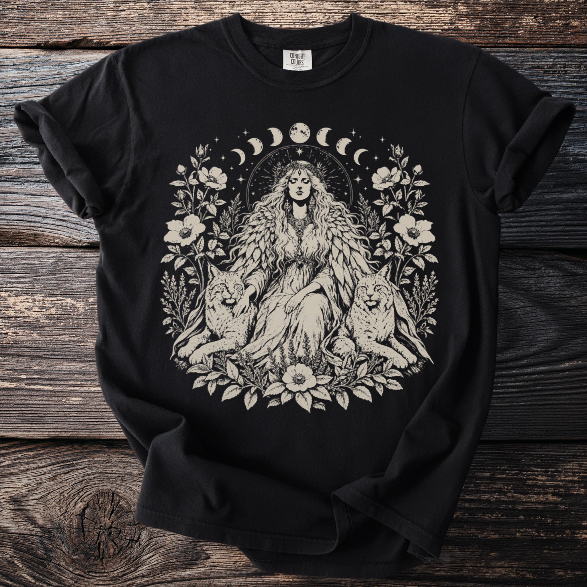 Black t-shirt with a graphic of a woman with wings, two lynx, and floral crescent moon details.