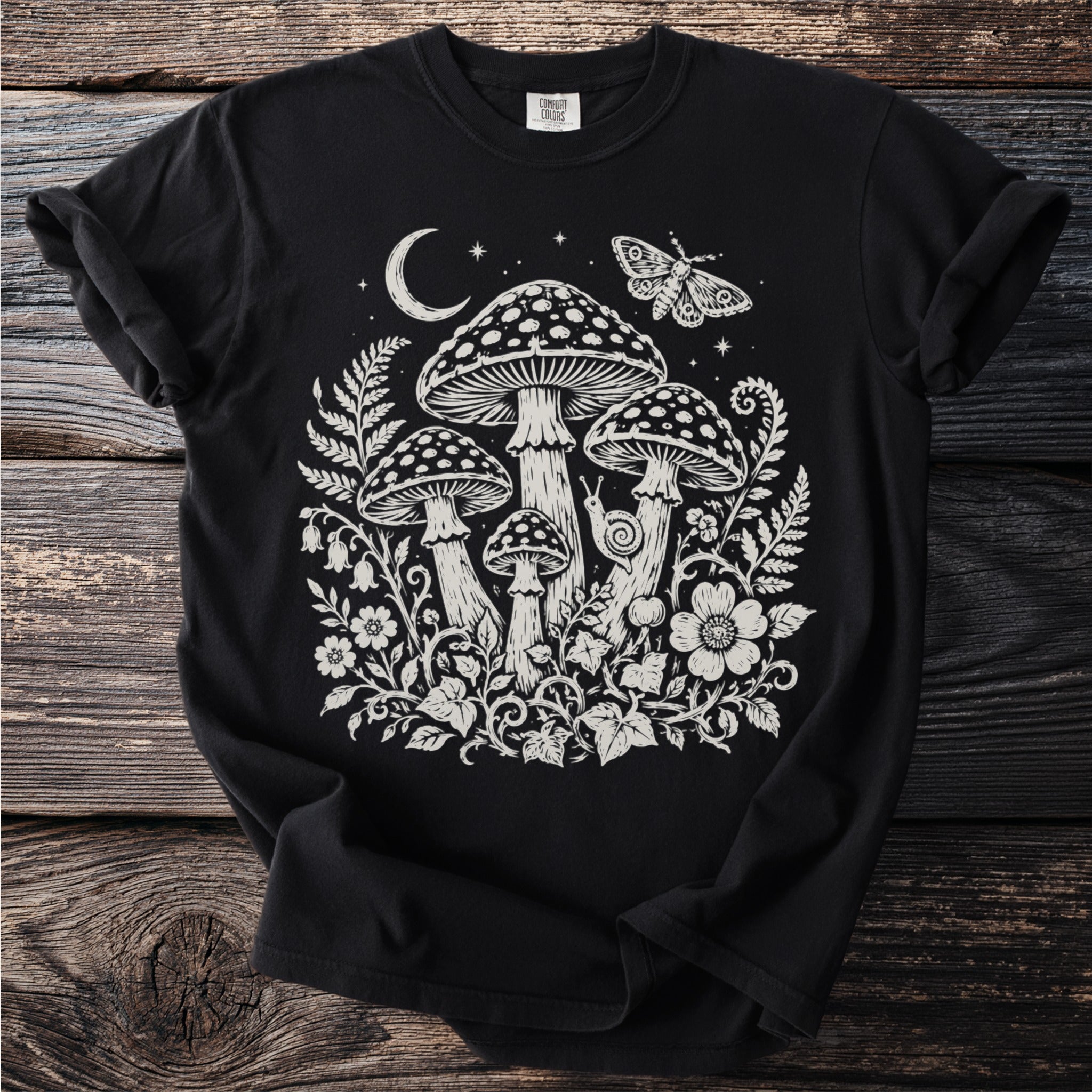 Black t-shirt with white intricate nature design featuring mushrooms, moth, moon, and flowers.