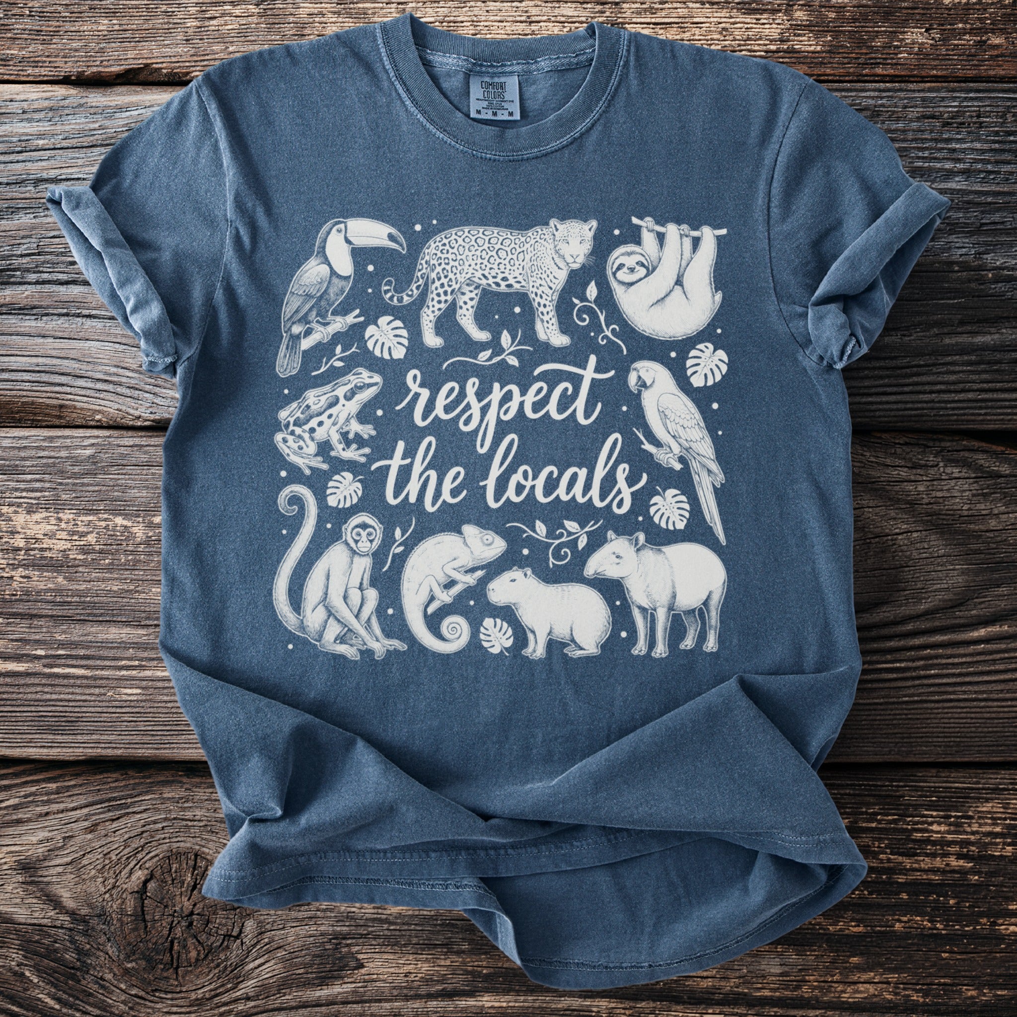 Blue t-shirt with line drawing of jungle animals and text "respect the locals".