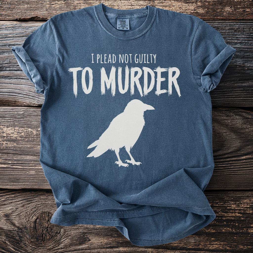 Blue t-shirt with white text "I PLEAD NOT GUILTY TO MURDER" and a raven graphic.