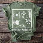 Green t-shirt with graphic of Bigfoot, possum, raccoon, and insect with "protect wildlife" text.