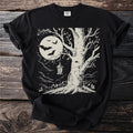 Black t-shirt with a vintage illustration of a tree, moon, bats, and a lantern.