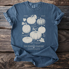 Blue t-shirt with illustrations and names of various heirloom pumpkins.
