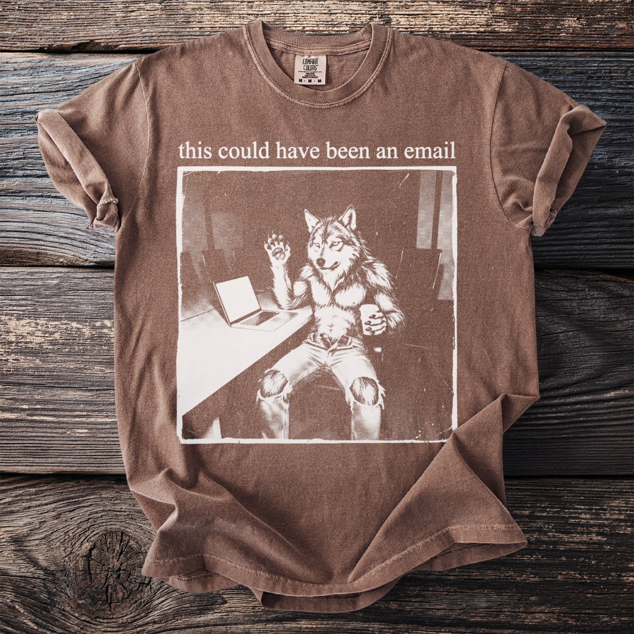 Brown t-shirt with graphic of anthropomorphic wolf at desk saying "this could have been an email."