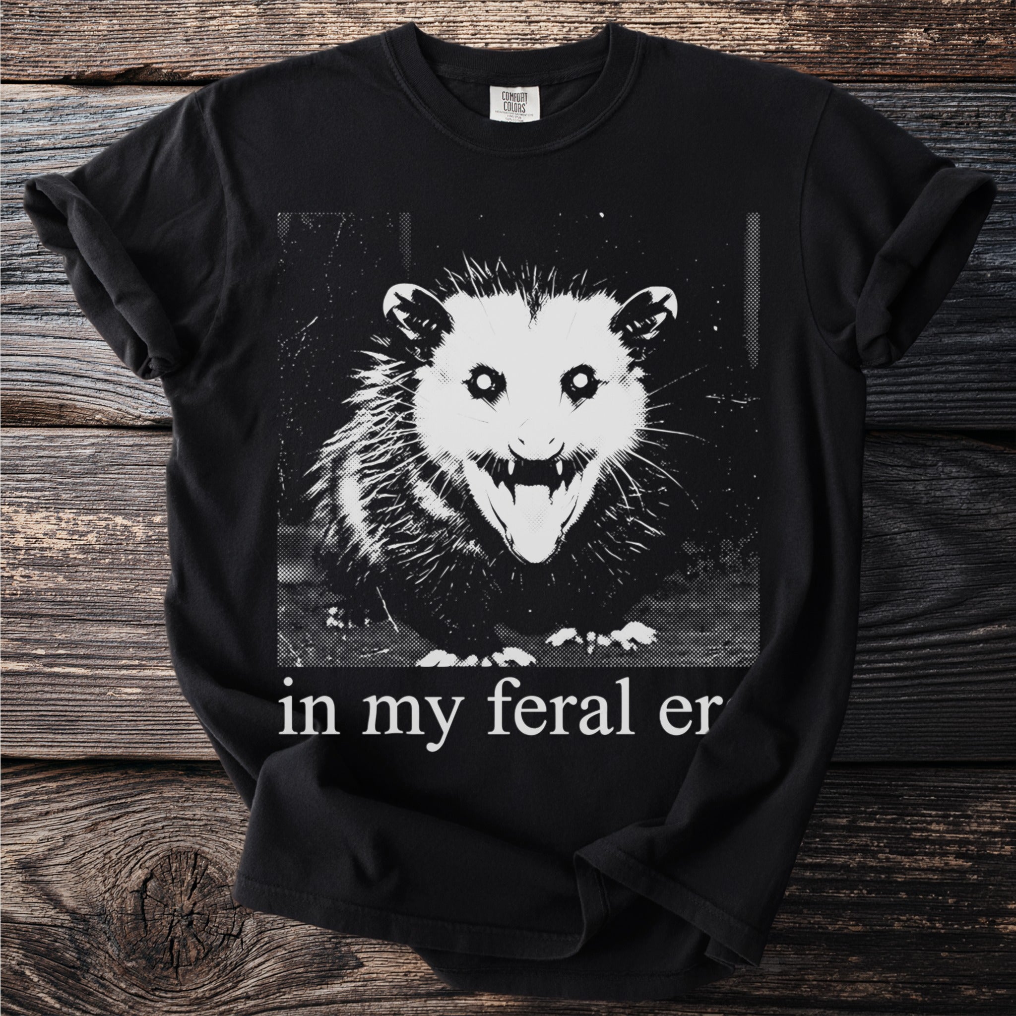 Black t-shirt with a distressed graphic of an opossum and the text "in my feral er."
