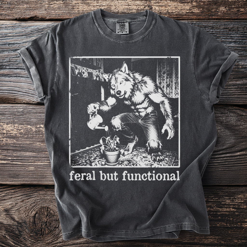 Dark grey t-shirt with werewolf watering plant graphic and "feral but functional" text.