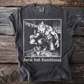 Dark grey t-shirt with werewolf watering plant graphic and "feral but functional" text.