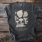 T-shirt with black ink illustration of various fungi and text "The Mycological Cabinet".