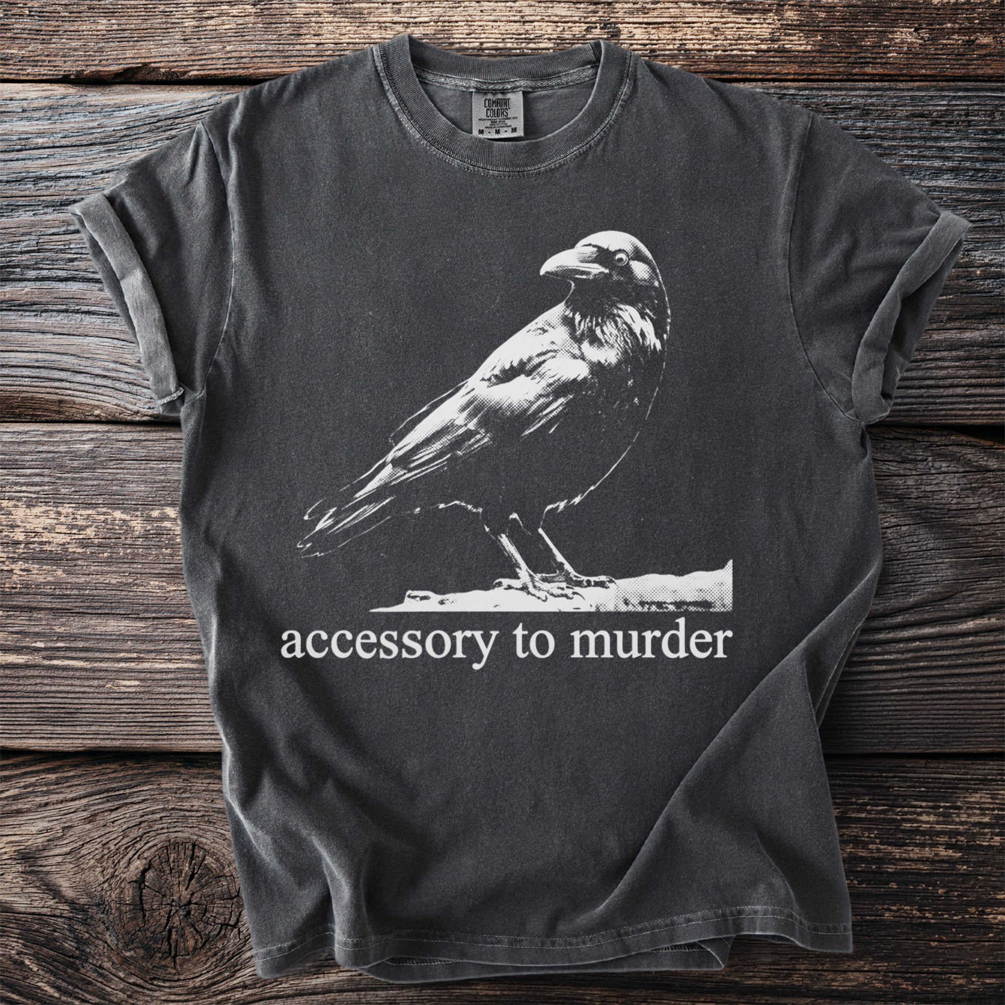 Dark gray t-shirt with a white crow graphic and "accessory to murder" text.