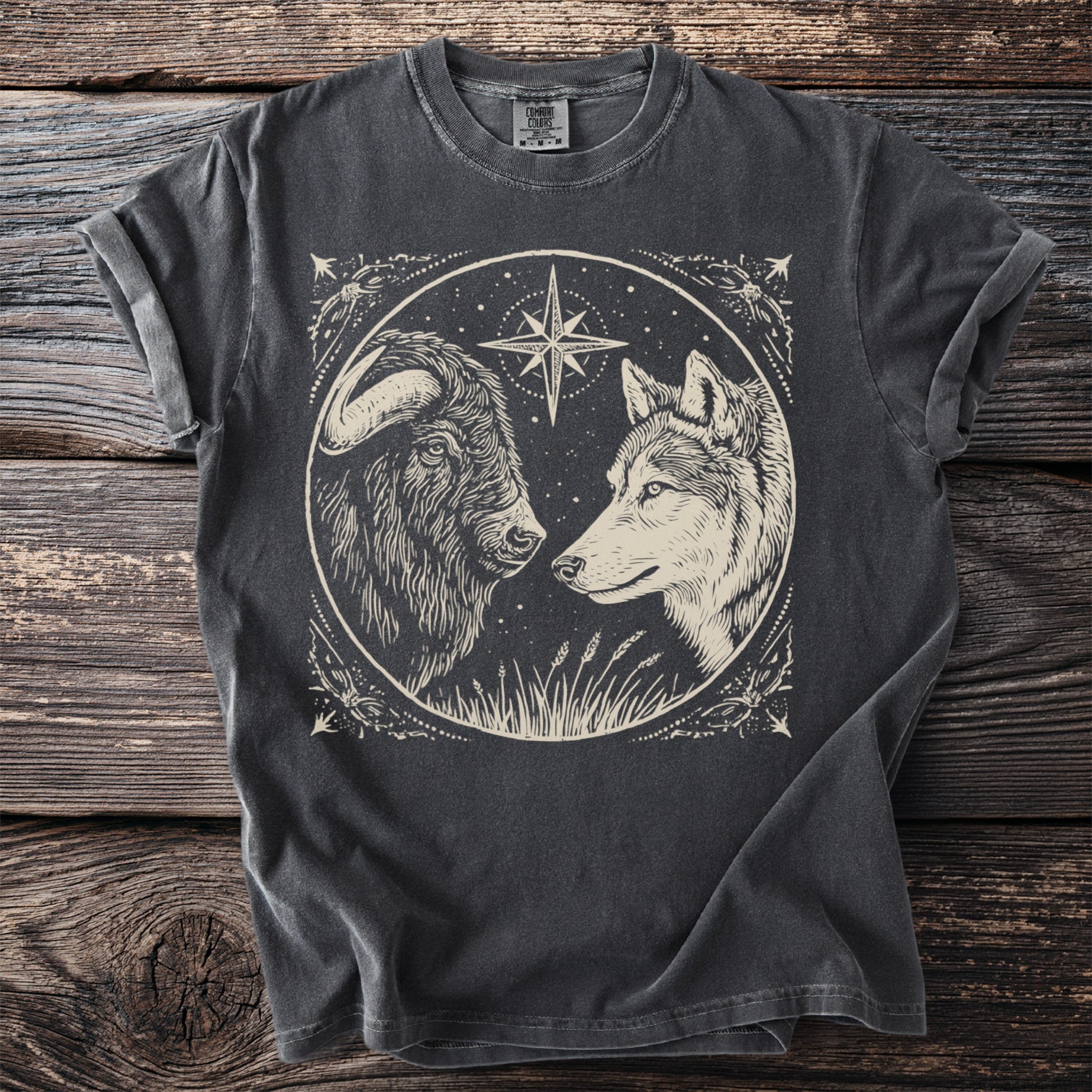 Pepper t-shirt with a musk ox and wolf facing beneath a north star.