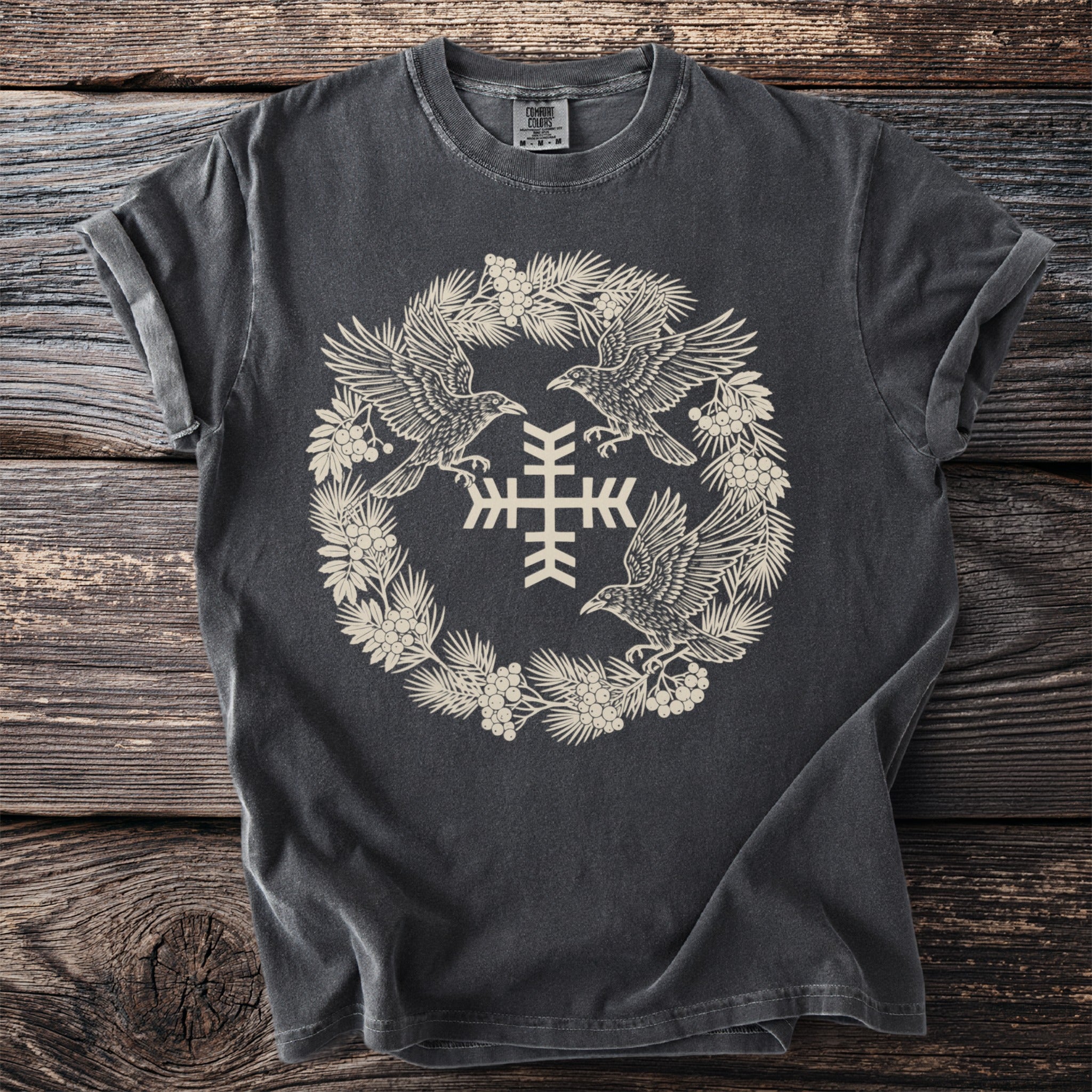 Dark grey t-shirt with a circular design of ravens, berries, and a snowflake symbol.