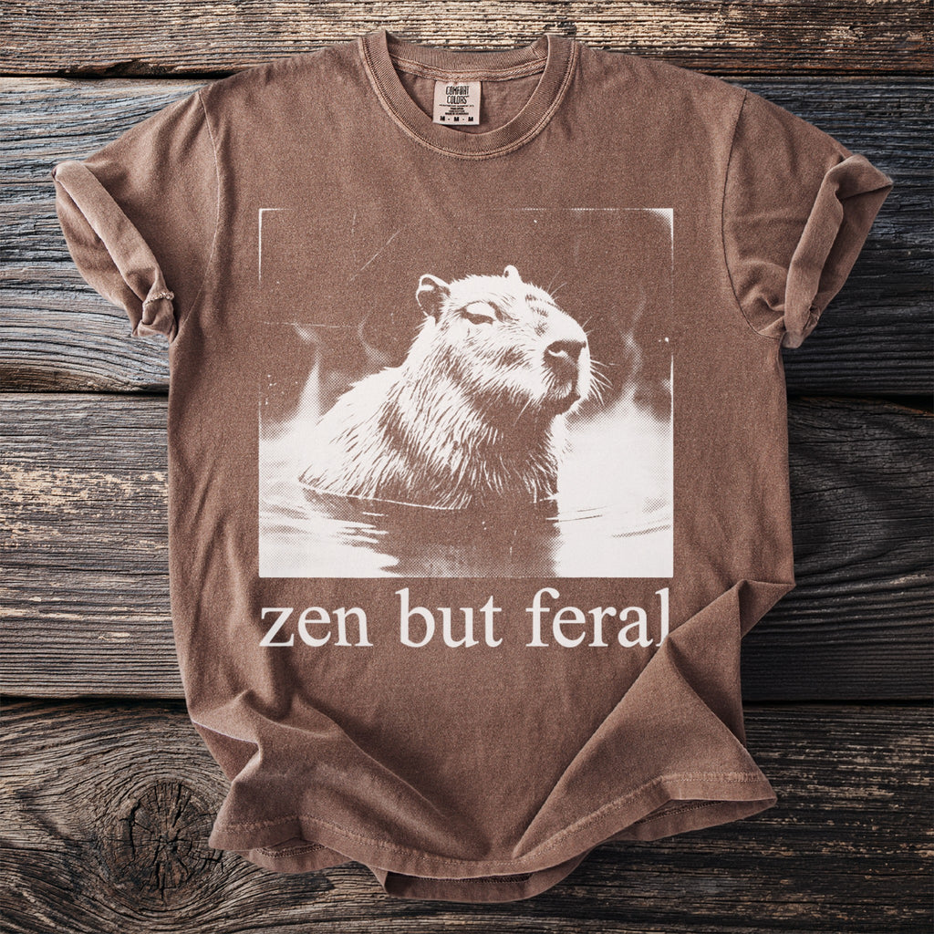 Brown t-shirt with a vintage capybara graphic and text "zen but feral".