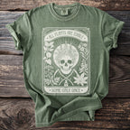 Green t-shirt with skull, plants, scythes, potion bottle, and text "All Plants Are Edible, Some Only Once."