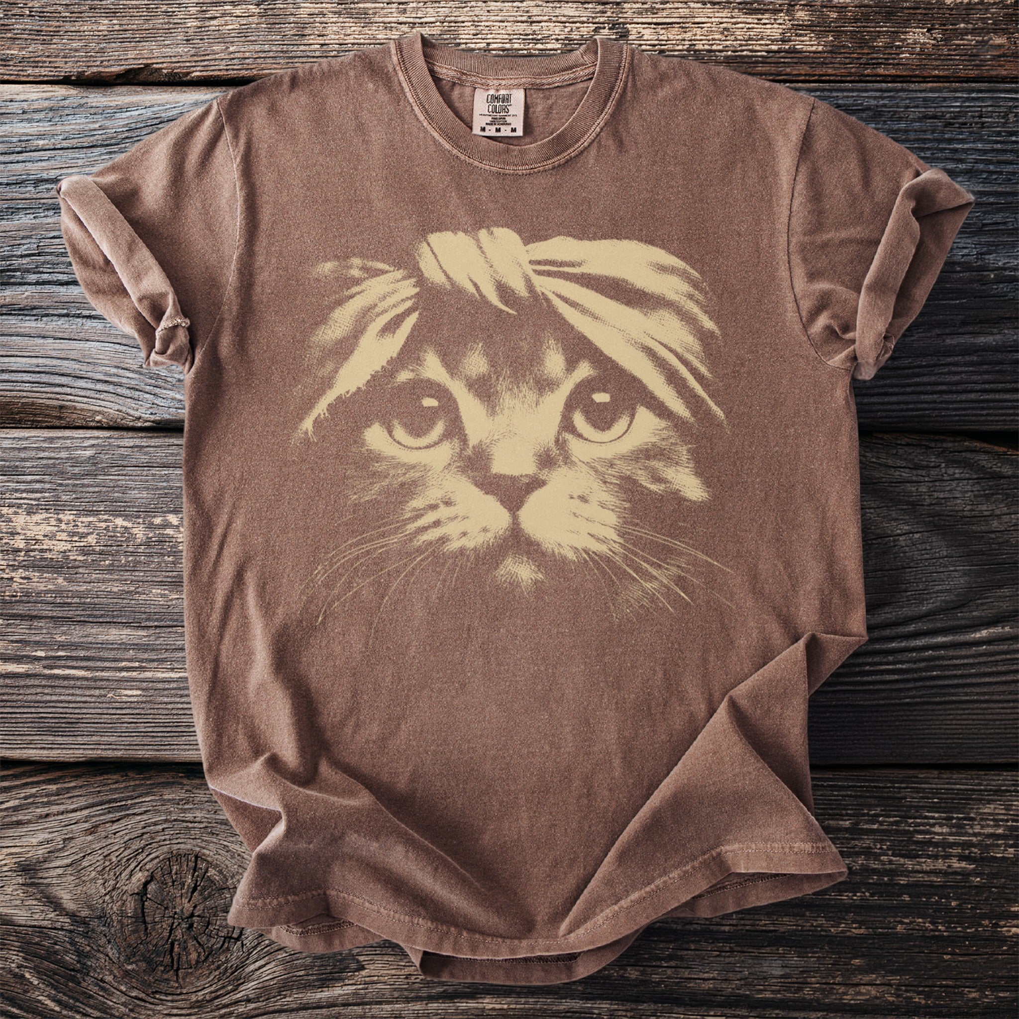 Brown t-shirt featuring a light tan graphic of a cat wearing a headband.