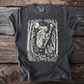 Dark grey t-shirt with a graphic of a witch riding in a cauldron through a forest.