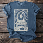 T-shirt with a ritualistic table scene featuring a cat, pentagram, and candle under a moonlit window.