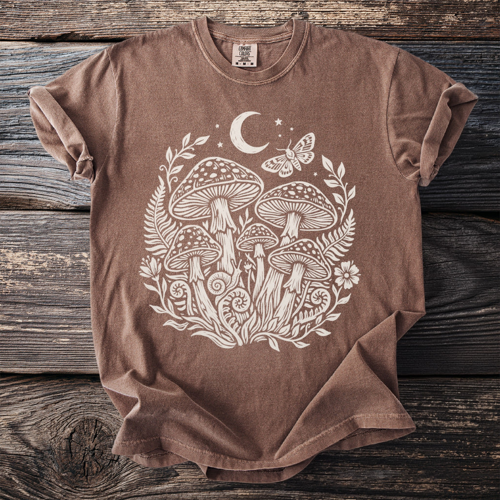 Brown t-shirt with white mushroom, moon, moth, and floral graphic.