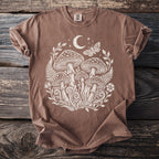 Brown t-shirt with white mushroom, moon, moth, and floral graphic.