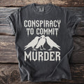 Dark gray t-shirt with white text "CONSPIRACY TO COMMIT MURDER" and three crows.