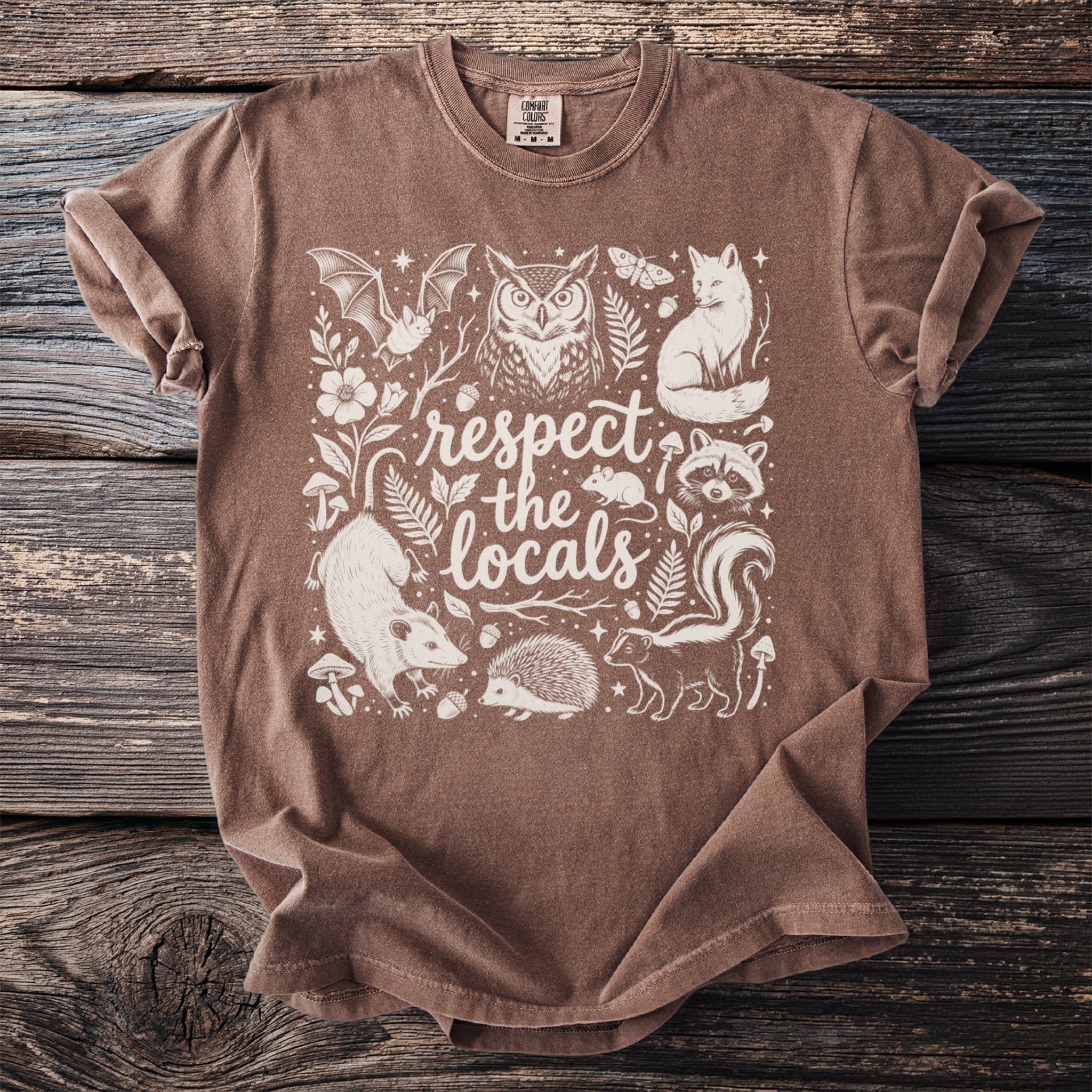Brown t-shirt with white screen print featuring woodland creatures and the text "respect the locals."