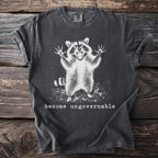 Dark grey t-shirt with a graphic of an angry raccoon and text "become ungovernable".