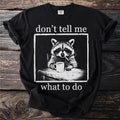 Black t-shirt with a raccoon smoking a cigarette and holding a coffee mug. "don't tell me what to do" text.