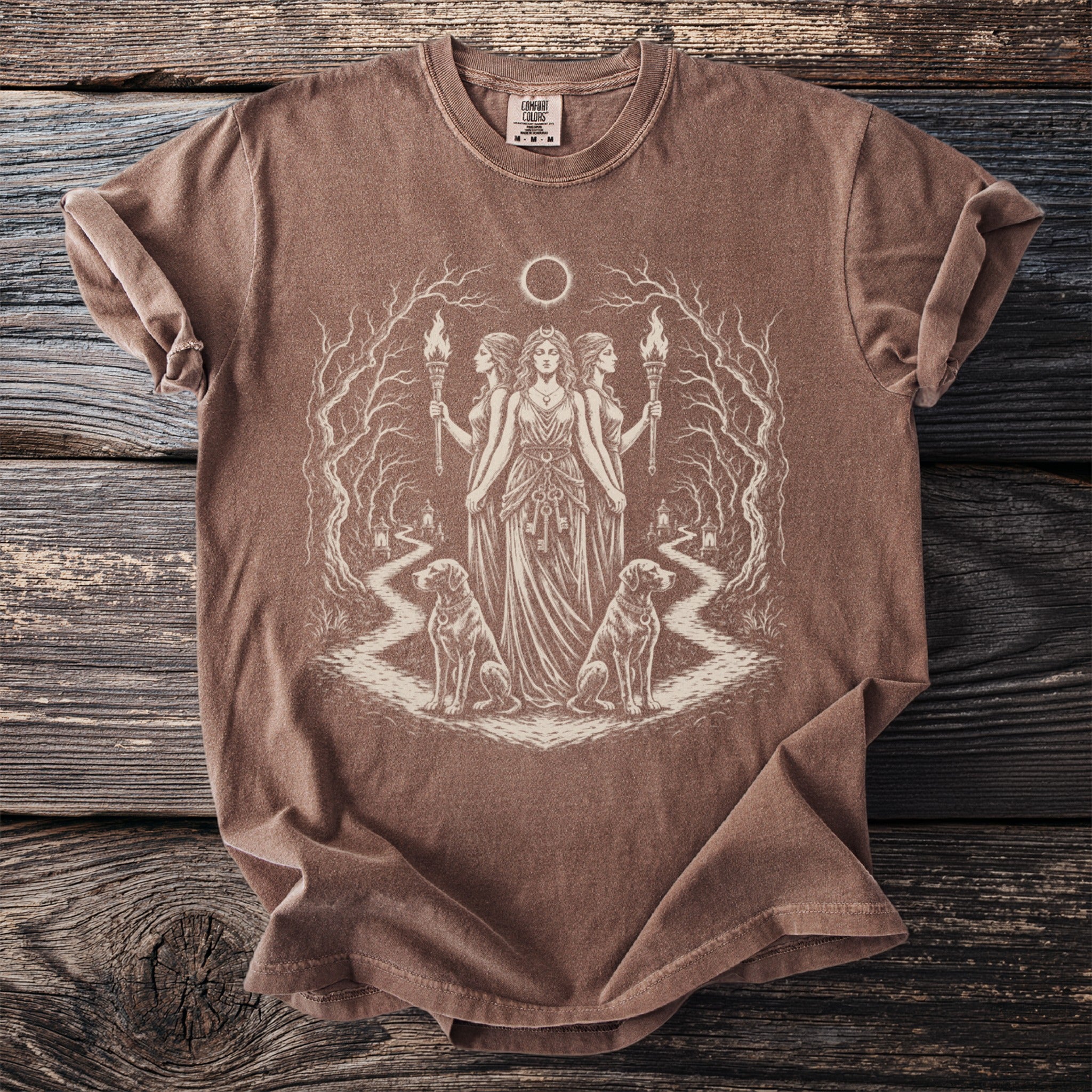 Brown t-shirt with a mystical print of three women holding torches and two dogs.