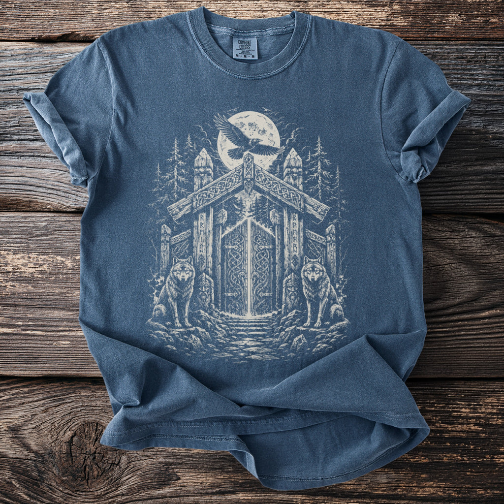 Blue t-shirt with viking-themed graphic of wolves, raven, and ornate gateway under moon.
