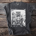 T-shirt graphic of a raccoon holding food inside an open refrigerator.
