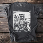 T-shirt graphic of a raccoon holding food inside an open refrigerator.