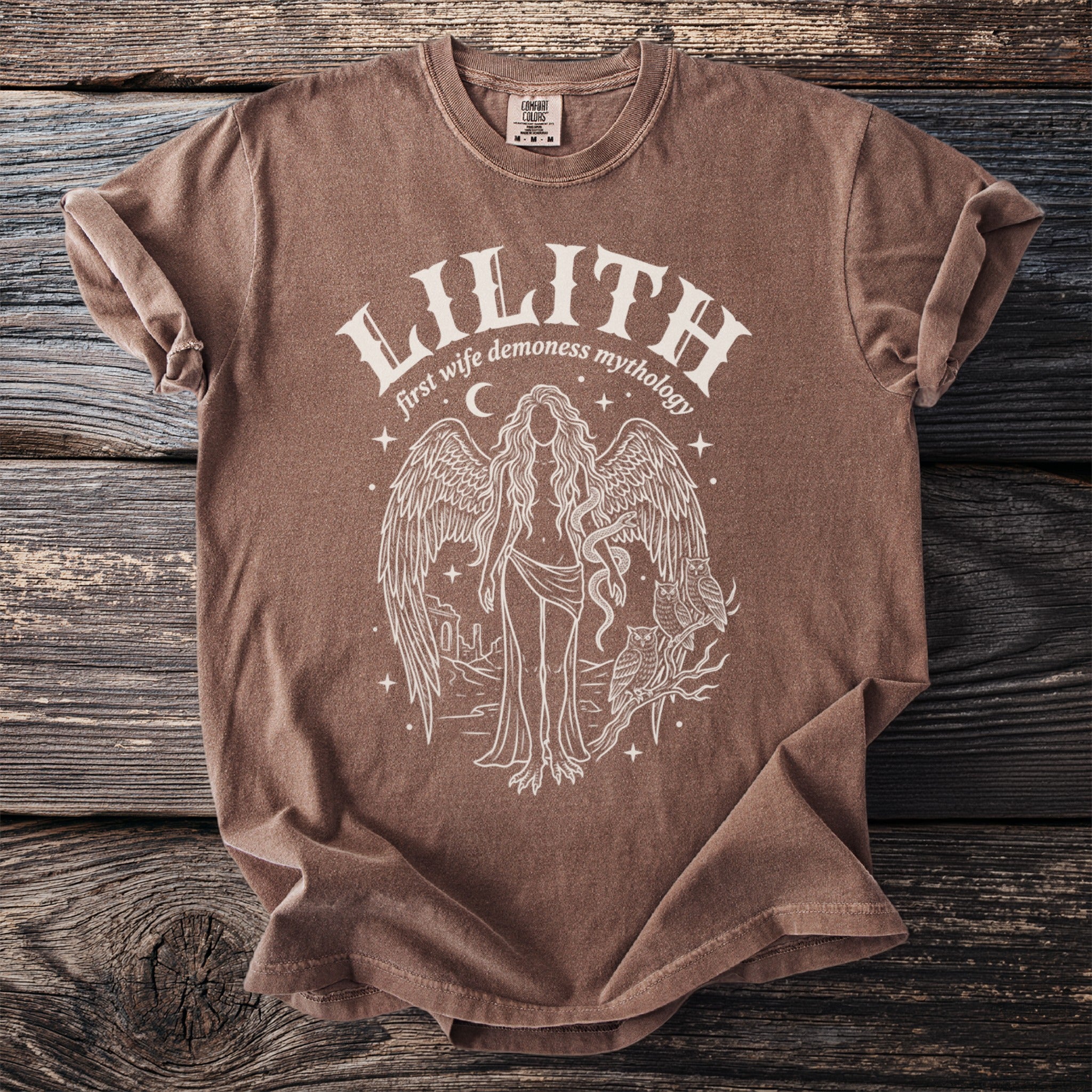 Brown t-shirt with white graphic of Lilith, first wife demoness mythology, wings and owls.