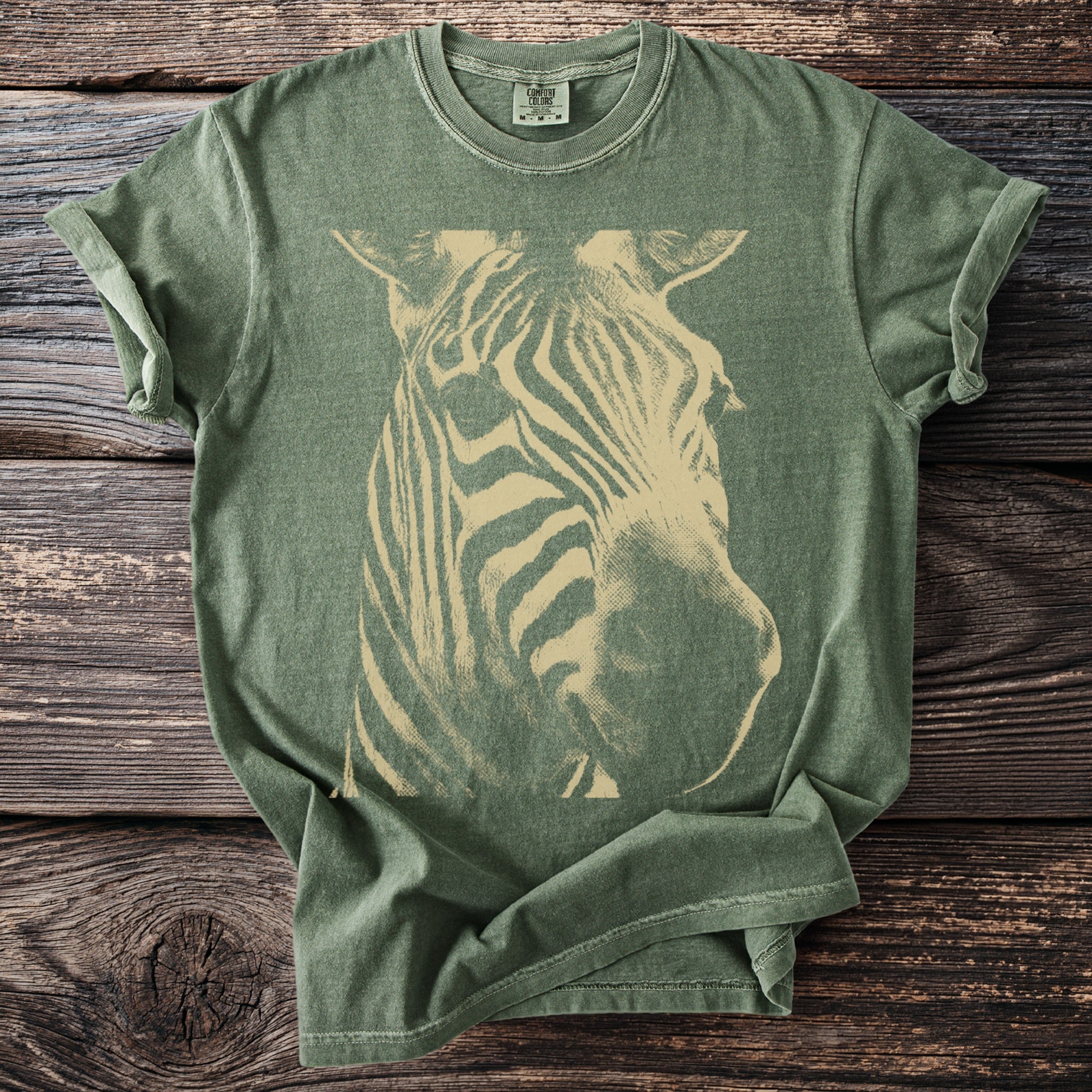 Green t-shirt with a vintage cream zebra head graphic and Comfort Colors label.
