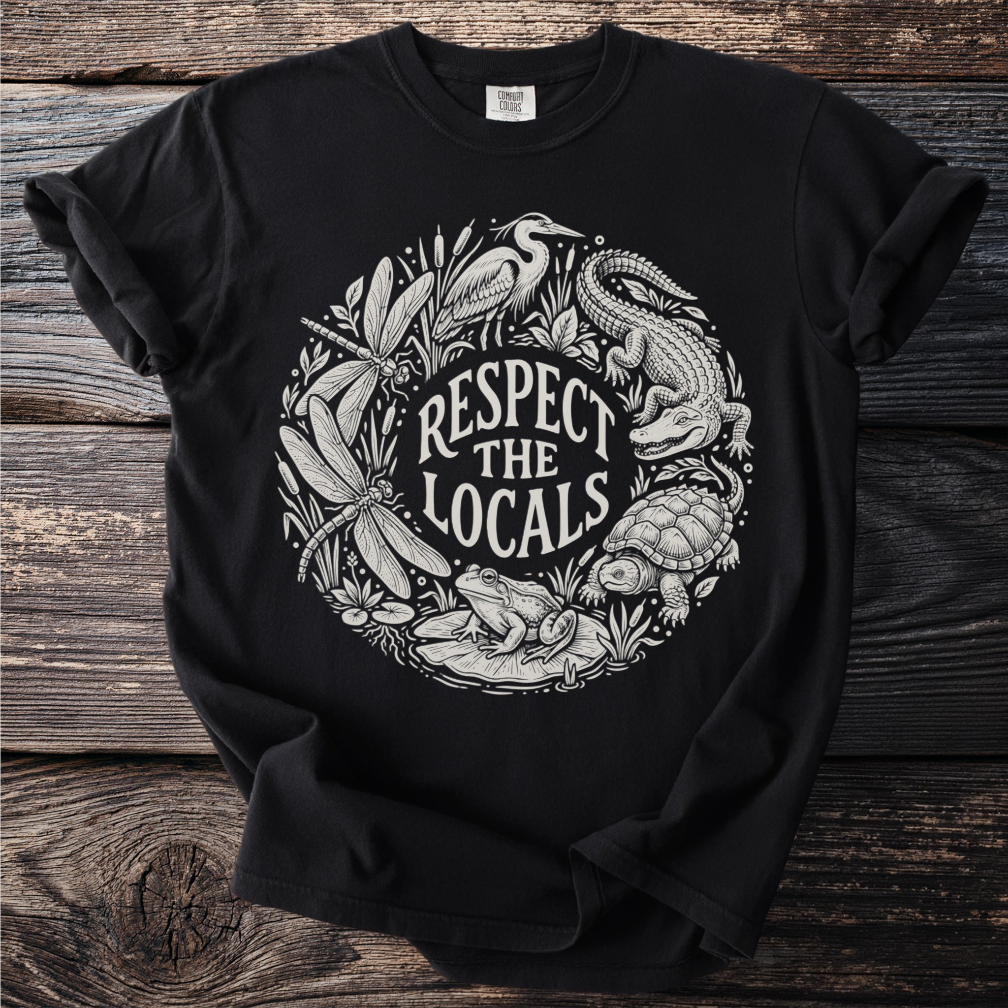 Black t-shirt with "Respect the Locals" text surrounded by dragonflies, frog, alligator, turtle, and heron.