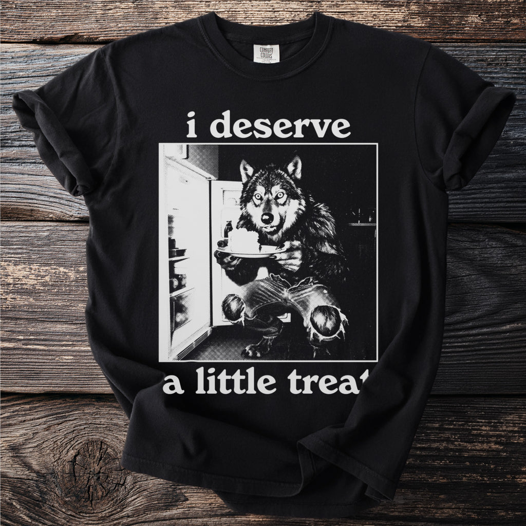 Black t-shirt with a wolf in torn jeans in front of a refrigerator holding cake.